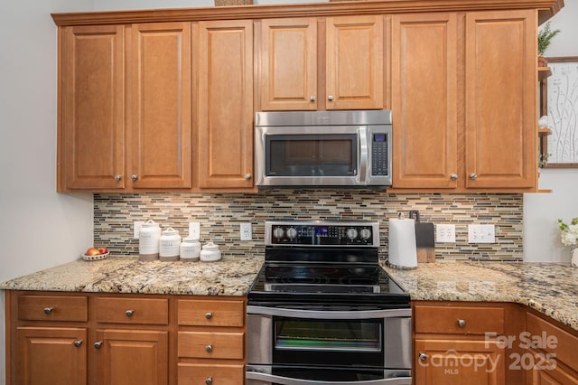 7988 Golf Course Dr N, Denver, NC 28037 - kitchen featuring appliances with stainless steel finishes, tasteful backsplash, light stone counters, and brown cabinetry