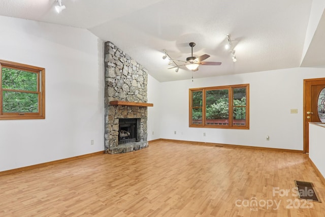 58 Oak Ter, Arden, NC 28704 - unfurnished living room featuring track lighting, a ceiling fan, light wood-type flooring, lofted ceiling, and a fireplace