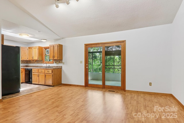 58 Oak Ter, Arden, NC 28704 - kitchen with freestanding refrigerator, light countertops, light wood-type flooring, dishwasher, and lofted ceiling