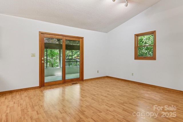 58 Oak Ter, Arden, NC 28704 - unfurnished room featuring healthy amount of natural light, wood finished floors, lofted ceiling, and a textured ceiling