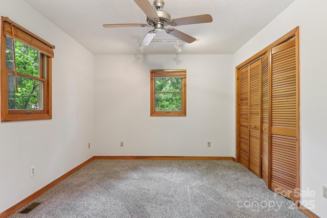 58 Oak Ter, Arden, NC 28704 - unfurnished bedroom with multiple windows, carpet floors, a closet, and a textured ceiling