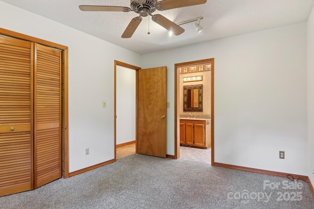 58 Oak Ter, Arden, NC 28704 - unfurnished bedroom featuring a closet, carpet floors, ceiling fan, a textured ceiling, and ensuite bath