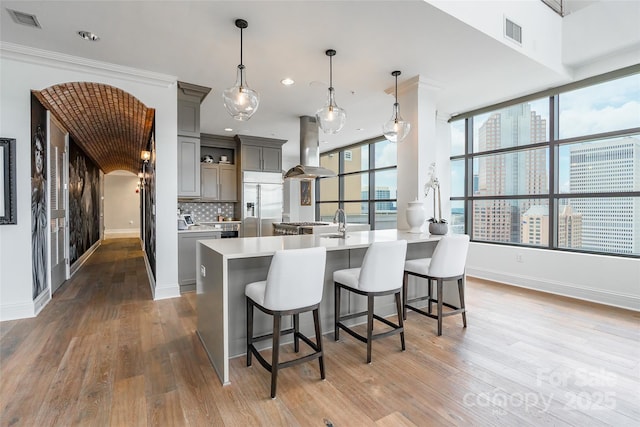 222 S Caldwell St # 2203, Charlotte, NC 28202 - kitchen featuring island exhaust hood, gray cabinets, stainless steel built in fridge, light countertops, and recessed lighting