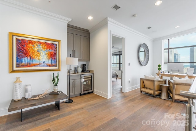 222 S Caldwell St # 2203, Charlotte, NC 28202 - interior space featuring wine cooler, gray cabinetry, ornamental molding, light wood-type flooring, and recessed lighting