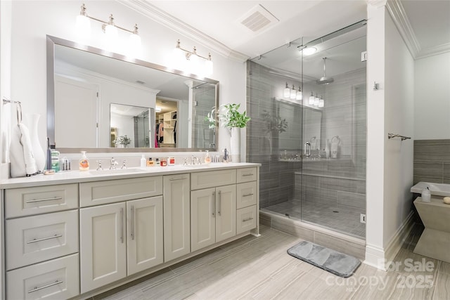 222 S Caldwell St # 2203, Charlotte, NC 28202 - bathroom featuring a shower stall, crown molding, double vanity, and a walk in closet