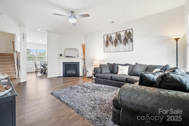 1343 Kent Downs Ave SW, Concord, NC 28027 - living room with stairway, dark wood-type flooring, ceiling fan, and a fireplace with flush hearth
