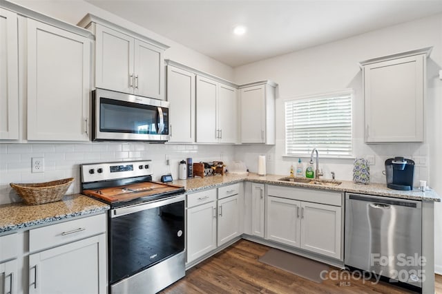 1343 Kent Downs Ave SW, Concord, NC 28027 - kitchen with appliances with stainless steel finishes, backsplash, dark wood finished floors, and light stone countertops