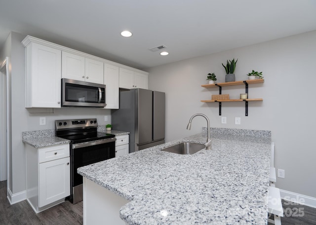 360 Sexton St, Kannapolis, NC 28081 - kitchen with stainless steel appliances, a peninsula, dark wood-style floors, white cabinets, and recessed lighting