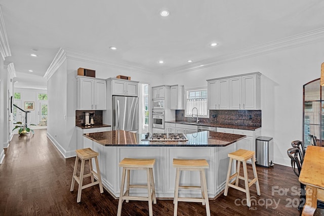 202 Caldwell Ln, Davidson, NC 28036 - kitchen featuring stainless steel appliances, dark wood finished floors, backsplash, a kitchen bar, and recessed lighting