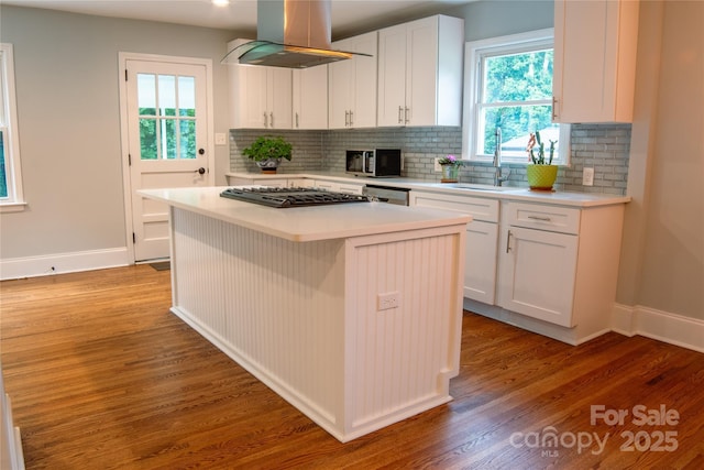2115 Arnold Dr, Charlotte, NC 28205 - kitchen with island range hood, light wood-style flooring, light countertops, and decorative backsplash