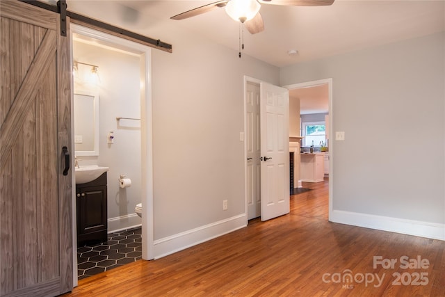2115 Arnold Dr, Charlotte, NC 28205 - unfurnished bedroom with a barn door, wood finished floors, ensuite bath, and ceiling fan