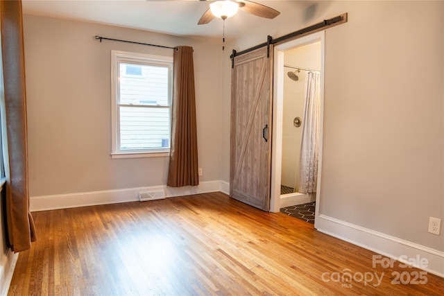 2115 Arnold Dr, Charlotte, NC 28205 - unfurnished bedroom with wood finished floors and a barn door