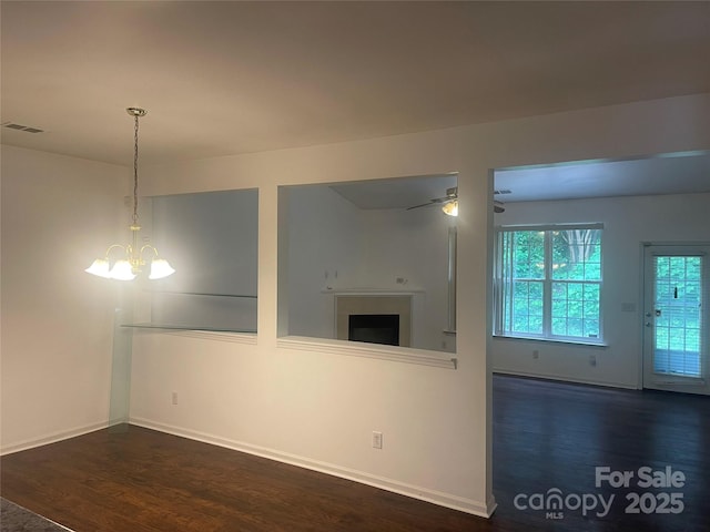 4454 Glenlea Commons Dr, Charlotte, NC 28216 - empty room featuring wood finished floors, a chandelier, a fireplace, and ceiling fan