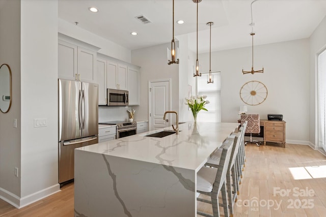 1315 E Blvd Unit 225, Charlotte, NC 28203 - kitchen with stainless steel appliances, light wood-style floors, recessed lighting, light stone countertops, and a breakfast bar