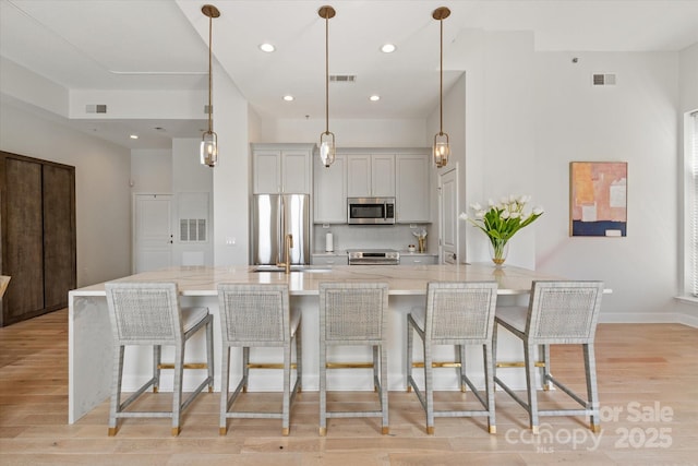 1315 E Blvd Unit 225, Charlotte, NC 28203 - kitchen with stainless steel appliances, light wood-type flooring, a breakfast bar, light stone countertops, and recessed lighting