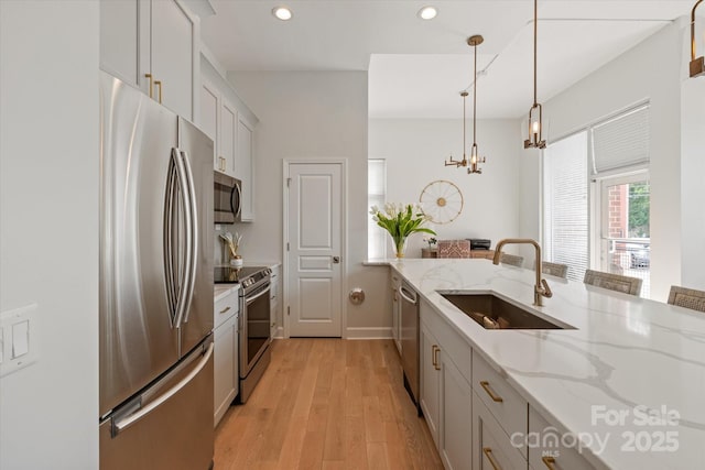 1315 E Blvd Unit 225, Charlotte, NC 28203 - kitchen featuring stainless steel appliances, recessed lighting, a chandelier, light wood-style flooring, and decorative light fixtures