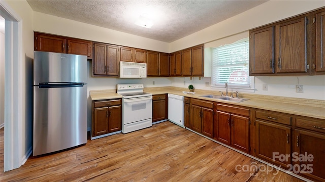 212 Fallen Timber Rd Unit 23, Hendersonville, NC 28791 - kitchen with white appliances, a textured ceiling, light countertops, and light wood-style floors