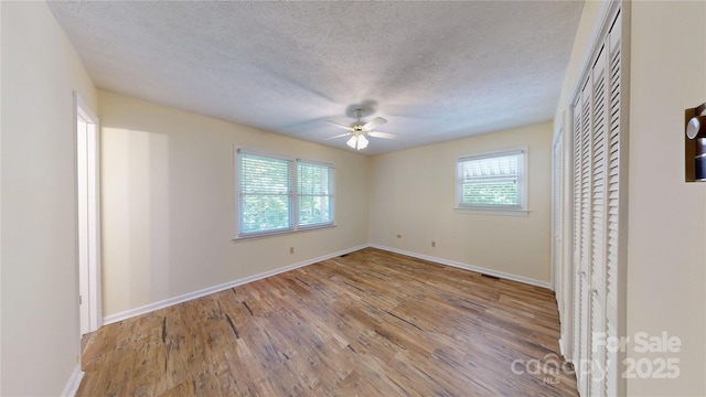 212 Fallen Timber Rd Unit 23, Hendersonville, NC 28791 - spare room featuring healthy amount of natural light, wood finished floors, a ceiling fan, and a textured ceiling