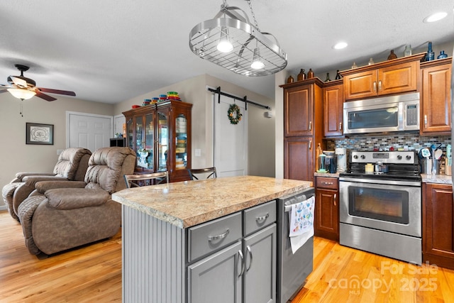 1467 Conway Dr, Granite Falls, NC 28630 - kitchen with appliances with stainless steel finishes, light countertops, open floor plan, ceiling fan, and tasteful backsplash