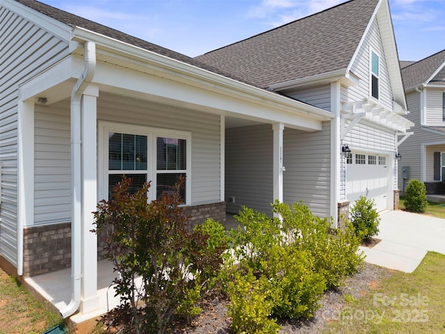 117 Carmine Ct, Troutman, NC 28166 - view of front facade with covered porch, a garage, driveway, a shingled roof, and brick siding