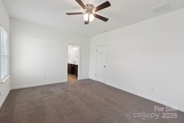 117 Carmine Ct, Troutman, NC 28166 - unfurnished bedroom featuring multiple windows, carpet, connected bathroom, and a ceiling fan