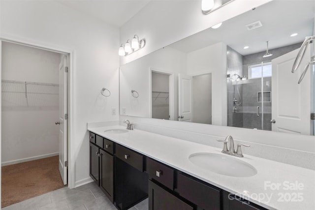 117 Carmine Ct, Troutman, NC 28166 - bathroom featuring a stall shower, double vanity, a walk in closet, and tile patterned flooring