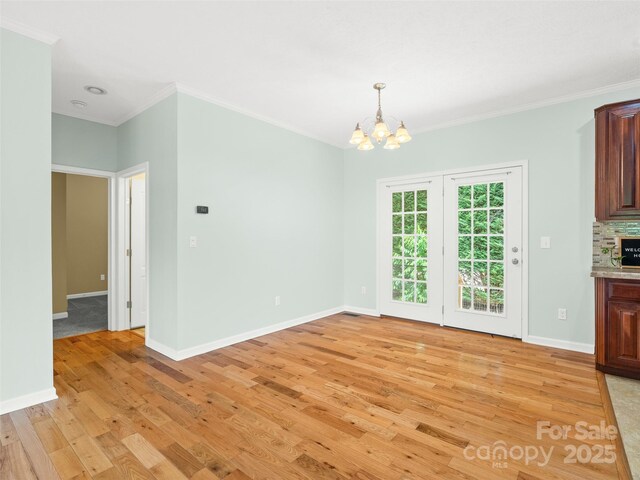 9 Farthings Dr, Arden, NC 28704 - unfurnished dining area with light wood-type flooring, a chandelier, and crown molding
