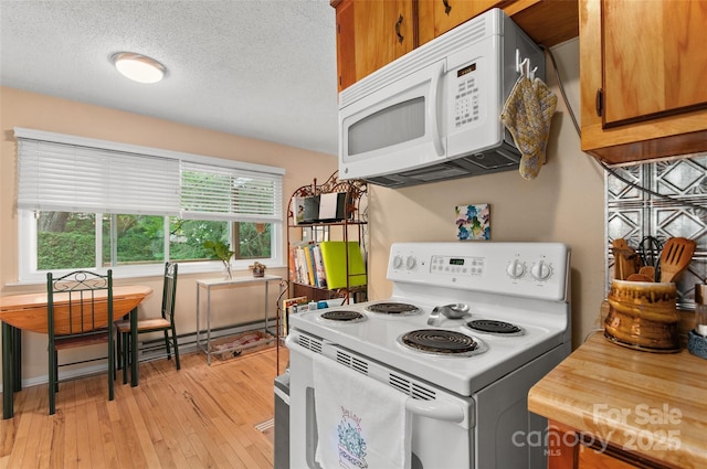 141 Elkwood Ave, Asheville, NC 28804 - kitchen with white appliances, brown cabinetry, light wood-type flooring, and a textured ceiling
