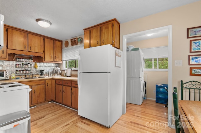 141 Elkwood Ave, Asheville, NC 28804 - kitchen with white appliances, brown cabinetry, light countertops, light wood-style flooring, and a textured ceiling