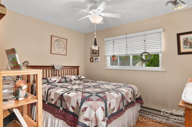 141 Elkwood Ave, Asheville, NC 28804 - bedroom with wood finished floors, a ceiling fan, and a baseboard heating unit