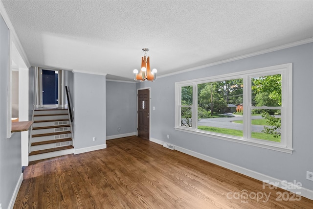 2000 Townsend Ave, Charlotte, NC 28205 - unfurnished living room with a chandelier, a textured ceiling, ornamental molding, wood finished floors, and stairway