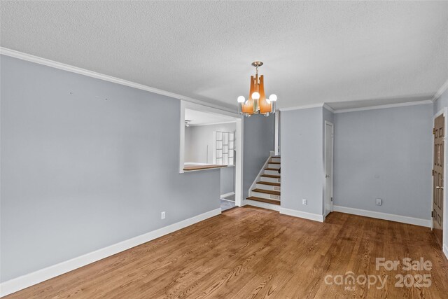 2000 Townsend Ave, Charlotte, NC 28205 - spare room featuring a chandelier, wood finished floors, a textured ceiling, ornamental molding, and stairs