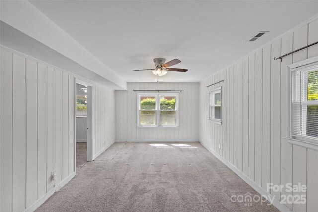 2000 Townsend Ave, Charlotte, NC 28205 - empty room with carpet flooring, plenty of natural light, a ceiling fan, and wooden walls