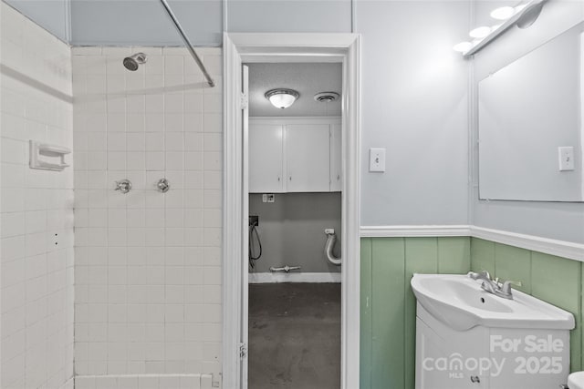 2000 Townsend Ave, Charlotte, NC 28205 - bathroom with vanity, tiled shower, wainscoting, and a decorative wall