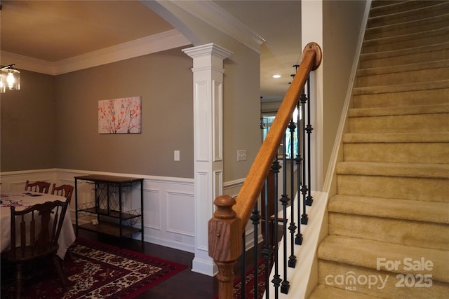 4003 Northerly Island Ct, Gastonia, NC 28056 - stairway featuring arched walkways, crown molding, decorative columns, a wainscoted wall, and wood finished floors