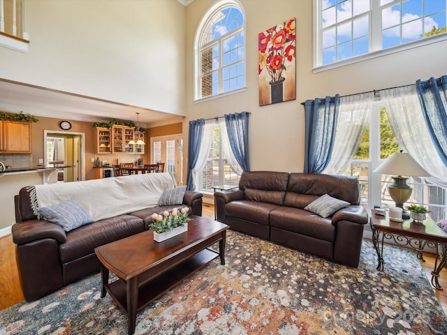 6523 Alba Rose Ln, Huntersville, NC 28078 - living room featuring a high ceiling, wood finished floors, healthy amount of natural light, a chandelier, and crown molding