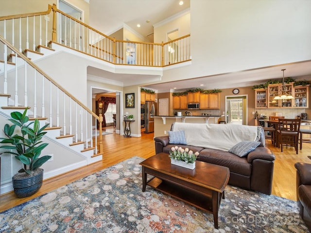6523 Alba Rose Ln, Huntersville, NC 28078 - living room featuring a high ceiling, light wood finished floors, ornamental molding, stairs, and recessed lighting