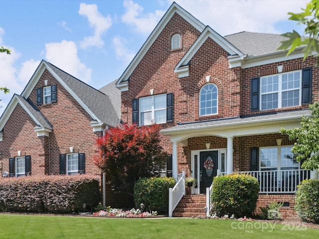 6523 Alba Rose Ln, Huntersville, NC 28078 - traditional home with brick siding, a shingled roof, a front yard, and covered porch