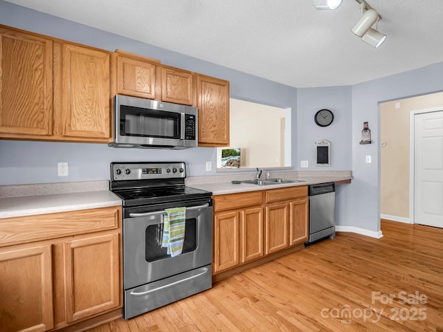 114 Fairway View Dr, Etowah, NC 28729 - kitchen with appliances with stainless steel finishes, light countertops, light wood finished floors, rail lighting, and a textured ceiling