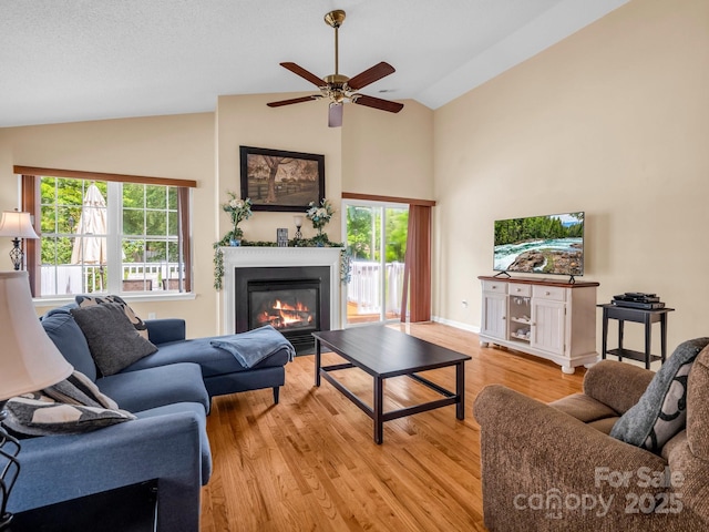 114 Fairway View Dr, Etowah, NC 28729 - living area with light wood-style flooring, a glass covered fireplace, a ceiling fan, and high vaulted ceiling