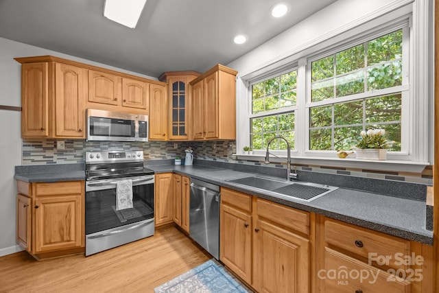2 Enka Orchard St Unit 21A, Candler, NC 28715 - kitchen featuring appliances with stainless steel finishes, light wood-style floors, tasteful backsplash, dark countertops, and recessed lighting