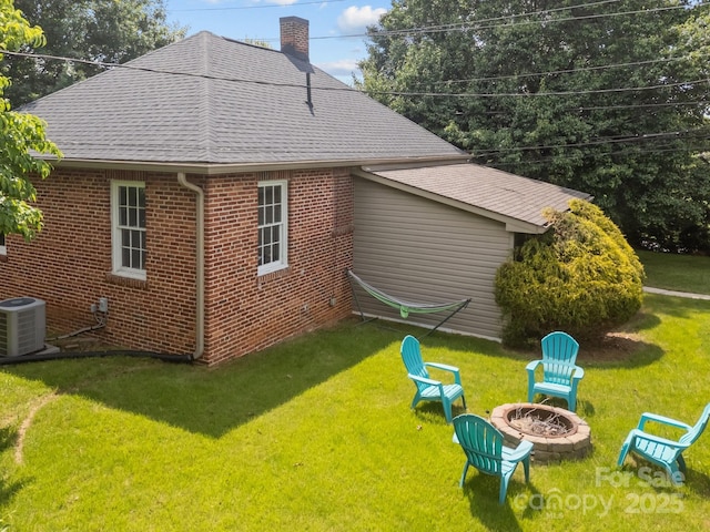 2 Enka Orchard St Unit 21A, Candler, NC 28715 - view of property exterior with a chimney, brick siding, an outdoor fire pit, roof with shingles, and a lawn