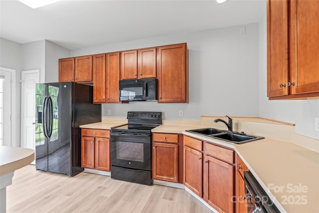 12452 Stratfield Place Cir, Pineville, NC 28134 - kitchen with black appliances, light countertops, light wood-style flooring, and brown cabinetry