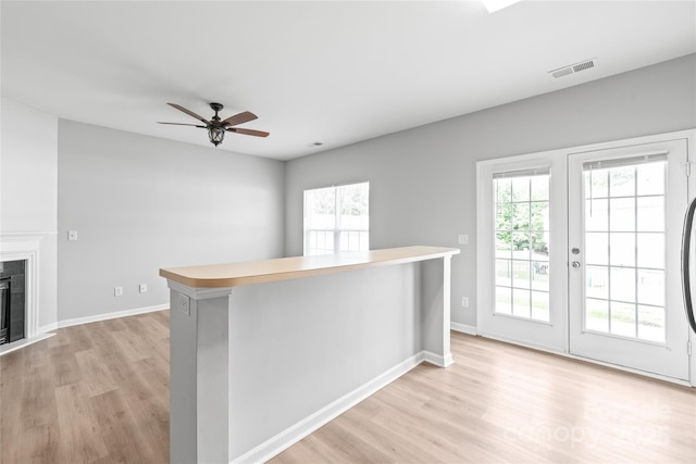 12452 Stratfield Place Cir, Pineville, NC 28134 - kitchen with light wood-style floors, a ceiling fan, a fireplace, and french doors