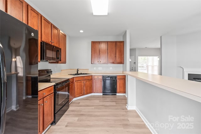 12452 Stratfield Place Cir, Pineville, NC 28134 - kitchen with black appliances, light wood-style flooring, light countertops, brown cabinets, and recessed lighting
