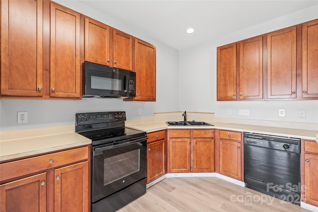 12452 Stratfield Place Cir, Pineville, NC 28134 - kitchen featuring black appliances, light wood-style floors, light countertops, brown cabinetry, and recessed lighting