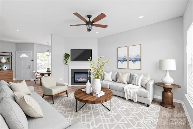 12452 Stratfield Place Cir, Pineville, NC 28134 - living room with light wood finished floors, a ceiling fan, recessed lighting, and a glass covered fireplace