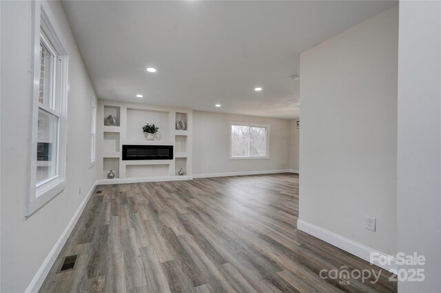 238 Lincoln Dr, Forest City, NC 28043 - unfurnished living room with recessed lighting, wood finished floors, a glass covered fireplace, and built in features