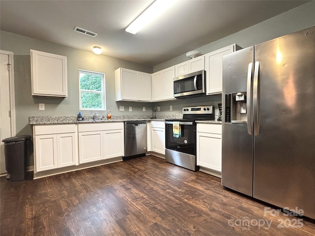 1916 Country Way, Hickory, NC 28601 - kitchen with stainless steel appliances, dark wood-type flooring, white cabinets, and light stone counters