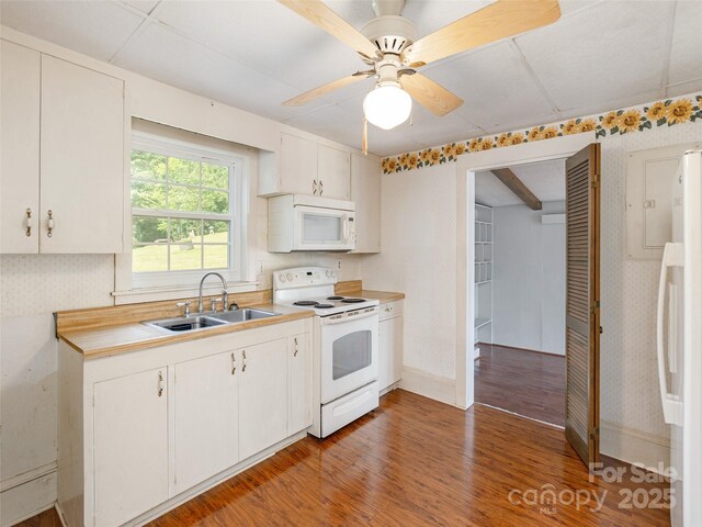34 Lockhart Rd, Tryon, NC 28782 - kitchen with white appliances, wallpapered walls, light wood-style floors, light countertops, and white cabinetry